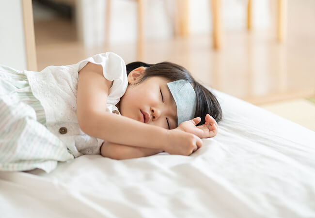 おでこに冷却シートを貼り眠る女の子