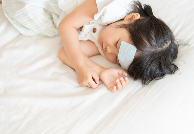 おでこに冷却シートを貼り眠る女の子